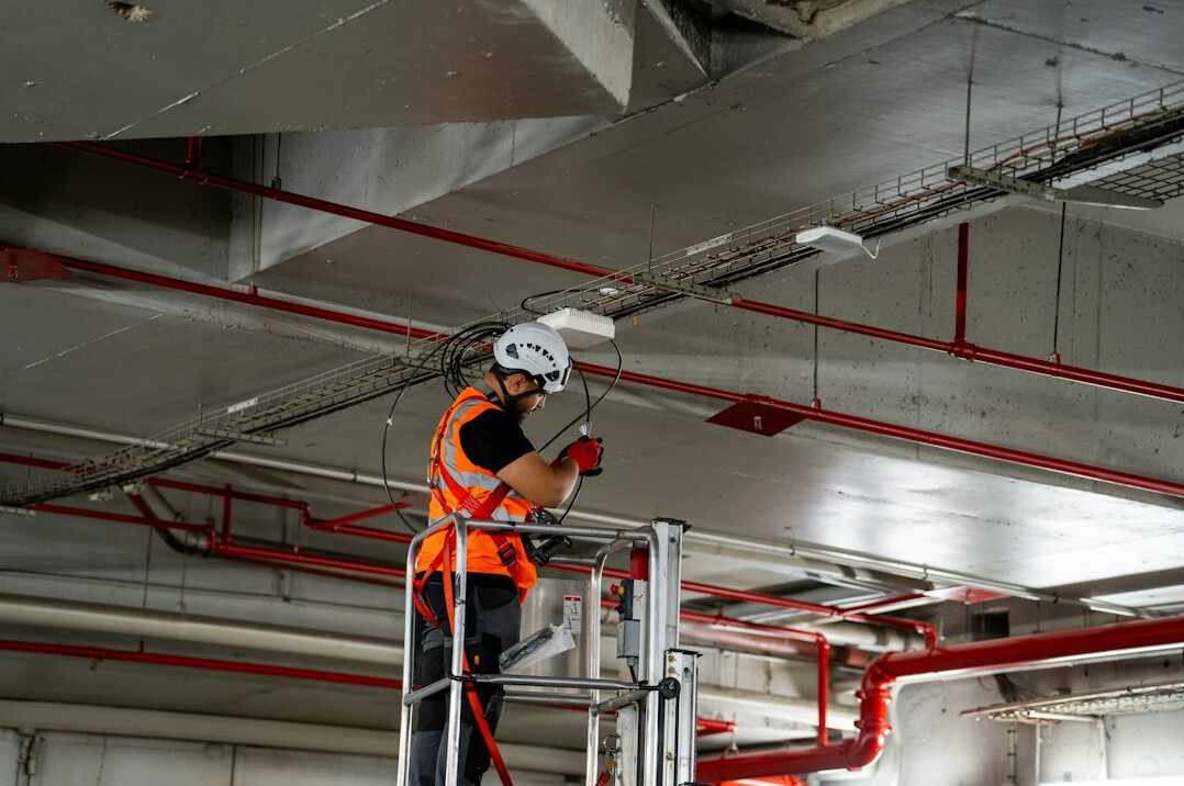 Repair technician in hard hat checking a tablet on site